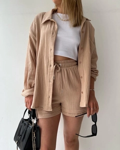 Detail of beige long-sleeve shirt and drawstring shorts set in textured crepe fabric