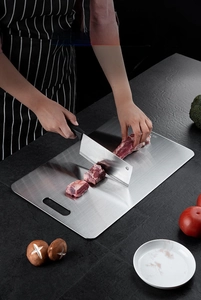 Slicing meat on a SUS 304 stainless steel cutting board with an easy-grip handle hole