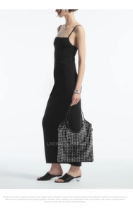 Chic black tote bag with sparkling rhinestone mesh overlay held by model in black dress
