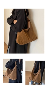 Brown suede hobo bag on model showing adjustable strap and large capacity in use