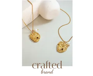 Detail view of irregular gold pendants with freshwater pearls on minimalist thin chains