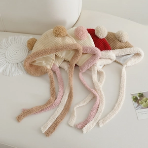 Detailansicht der Baby-Strickmützen mit Plüschfutter und zwei Pompons in vier Farben
