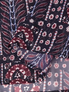Close-up of paisley floral pattern on navy blue fabric with subtle metallic gold threads