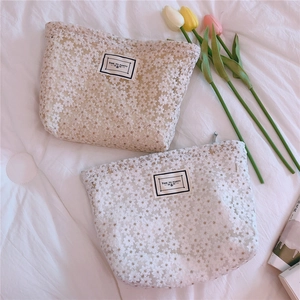 Detail of daisy lace embroidery pouches with Time to Party tags and floral accents