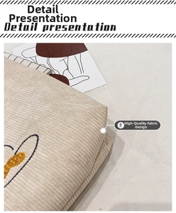 Detail view of beige corduroy shoulder bag with cute cartoon embroidery and soft texture