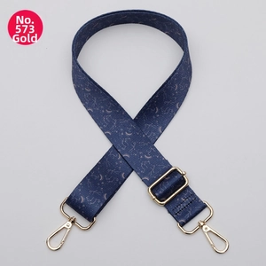 Dettaglio della tracolla etnica regolabile con stampe di costellazioni dorate e moschettoni in oro