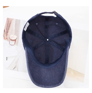 Close-up of blue washed cotton baseball cap interior showing 100% cotton label and stitching