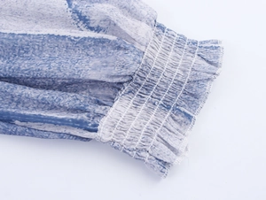 Détail de la manche en mousseline tie-dye bleue avec poignet froncé et volanté