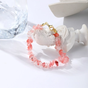 Detailed macro shot of irregular pink natural stone beads with a gold lobster clasp closure
