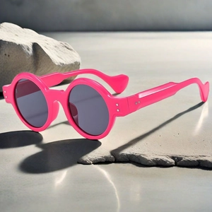 Detail of hot pink round sunglasses with metallic rivets and stylish wavy curved temples