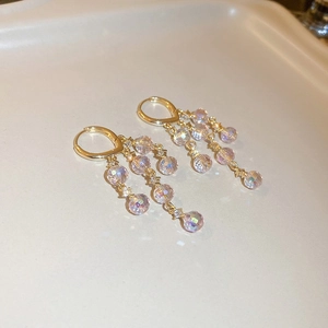 Detail of gold crystal tassel earrings with sparkling multifaceted beads on a tray