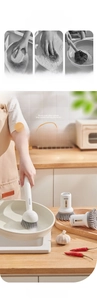 Detail of soap dispensing kitchen brush with long handle and interchangeable brush heads