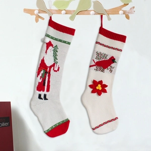 Knitted Christmas stockings with Santa and bird patterns hanging on a branch