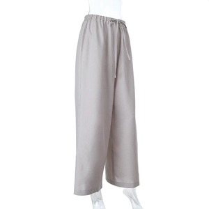 Dettaglio laterale dei pantaloni di lino grigi a vita alta con coulisse elastica in vita