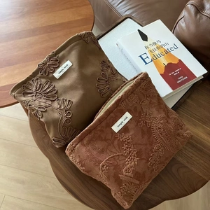 Detailed embroidery on suede makeup bags with vintage floral patterns and metal zippers