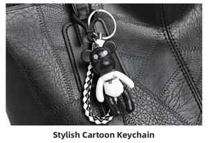 Detail of trendy cartoon bear charm with woven strap on black pebble leather tote bag