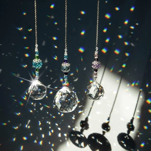 Detailed view of three crystal ball prisms casting vibrant rainbow light on a dark wall