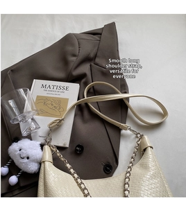 Detail of beige woven crossbody bag with silver chain and cute cloud plush pendant