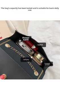 Interior view of black litchi leather bag showing capacity for power bank and cosmetics