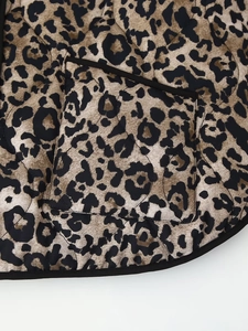 Detail shot of vintage leopard print quilted jacket showing fabric texture and pocket design
