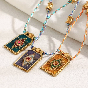 Close-up of 18K gold-plated eye tarot pendants with colorful enamel on braided cords
