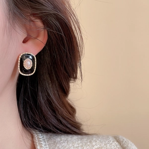 Gros plan sur une boucle d'oreille vintage avec perle et émail noir en doré