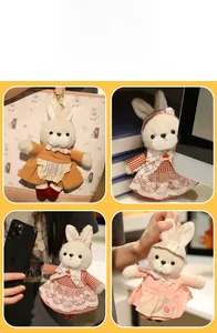 Dettaglio di portachiavi a coniglietto in peluche con abiti vintage e ganci in metallo