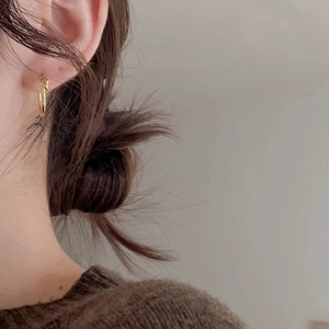 Minimalist S925 sterling silver gold knotted hoop earrings worn by a model