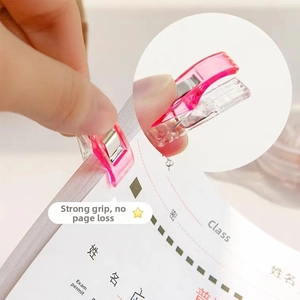 Detail view of pink transparent plastic sewing clip with strong spring for fabric binding