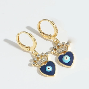 Dettaglio di orecchini a corona dorata con ciondolo a cuore blu e design evil eye