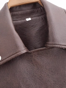 Close-up of the collar stitching and leather texture of a dark brown PU faux leather jacket