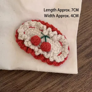 Detail of handmade crocheted cherry hair clip with dimensions length 7cm and width 4cm