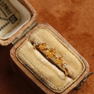 Macro detail of a vintage S925 silver ring with yellow gemstones in a jewelry box