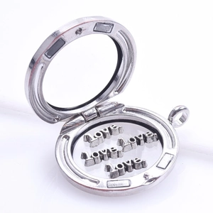 Macro view of a round floating charm locket with silver love letters inside