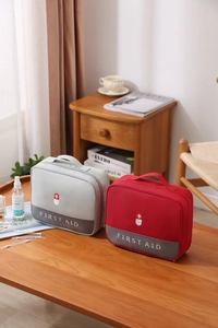 Close-up of portable first aid bag with durable handle and double zipper in gray and red