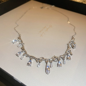 Silver branch necklace with water drop crystals on a jewelry card display