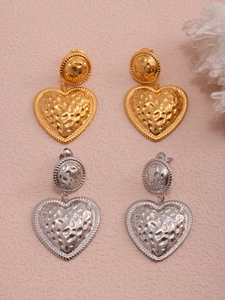 Macro detail of two-tone heart earrings featuring vintage hammered texture in gold and silver