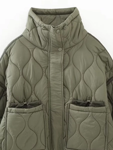 Detail of army green quilted jacket featuring a stand collar and snap buttons