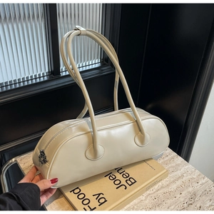 Chic beige cylinder underarm bag with smooth leather texture on a marble table