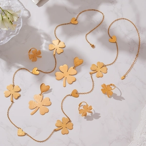 18k gold plated clover heart jewelry set with necklace earrings and rings on marble
