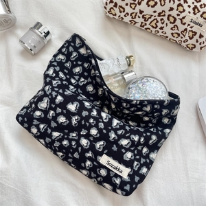 Detail of corduroy makeup bag featuring heart leopard print and zipper closure