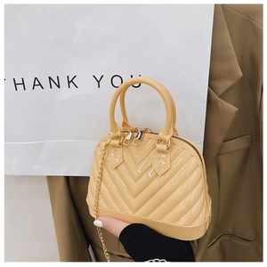 Detail view of yellow jelly shell bag featuring V-shaped quilted texture and gold chain