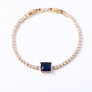 Detail of gold-plated tennis bracelet with white zircons and blue square centerpiece