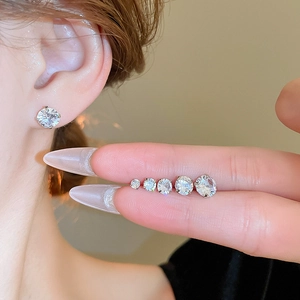 Minimalist silver stud earrings set with round cubic zirconia in five sizes on model