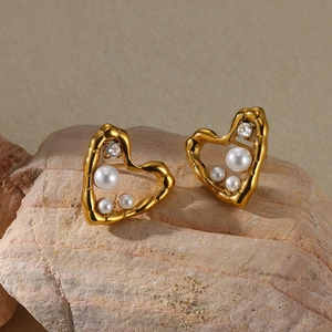 Macro detail of gold plated heart earrings with white pearls and clear cubic zirconia