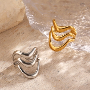 Polished gold and silver minimalist wavy multi-layer rings on natural stone background