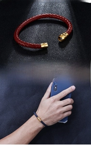 Detail of woven leather bracelets with high-gloss magnetic gold metal clasps