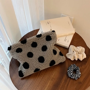 Plush polka dot lamb wool clutch bag and scrunchies set on a rustic wooden table