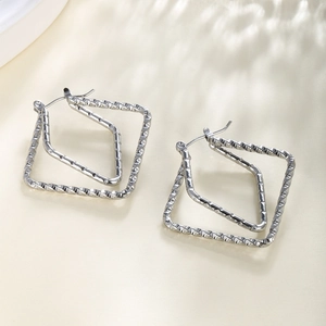Close-up of silver double rhombic earrings with twisted chain texture and lever back closure
