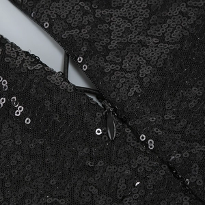 Vue détaillée de paillettes noires denses et d'une fermeture éclair invisible de robe